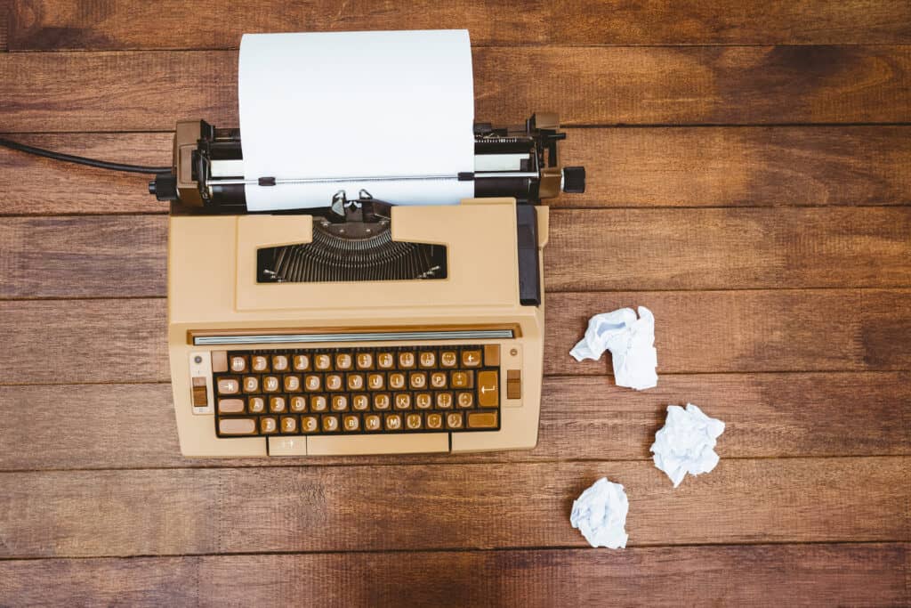 Old typewriter and paper on wood desk